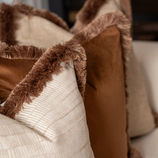 Close up of the Aldworth cushion's champagne and caramel double fringe
