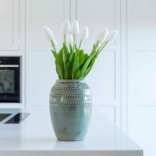 Decorative vase with white tulips on a kitchen counter