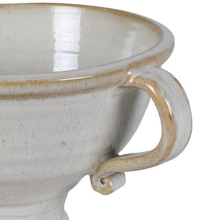Close-up of a ceramic footed vase with a handle on a white background