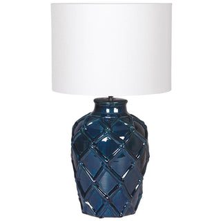 Blue textured table lamp with a white shade on a white background