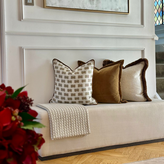 Lavenham cushion on a cream upholstered bench in a hallway