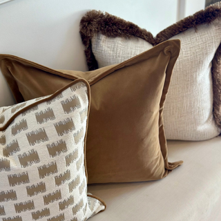 Lavenham cushion layered with camel velvet and cream cushions