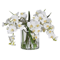 Artificial white orchid arrangement in a clear glass vase.