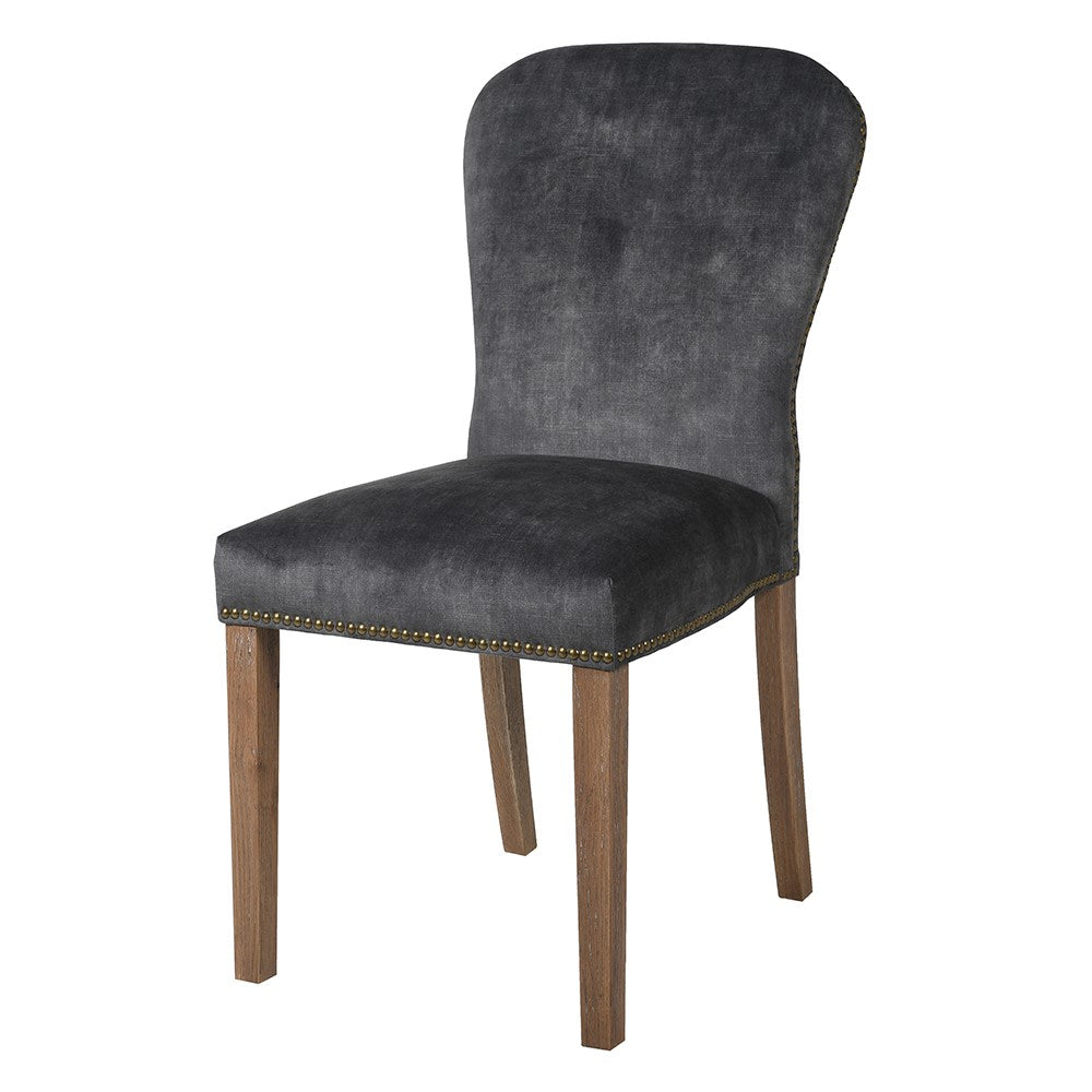 A stunning velvet chair in rich charcoal with brass stud detailing.