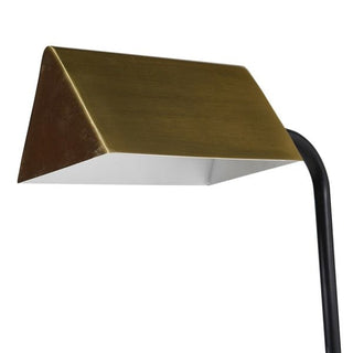 Modern floor lamp with gold shade and black base on a white background