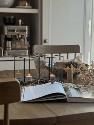 2 metal and glass hurricanes on a kitchen table