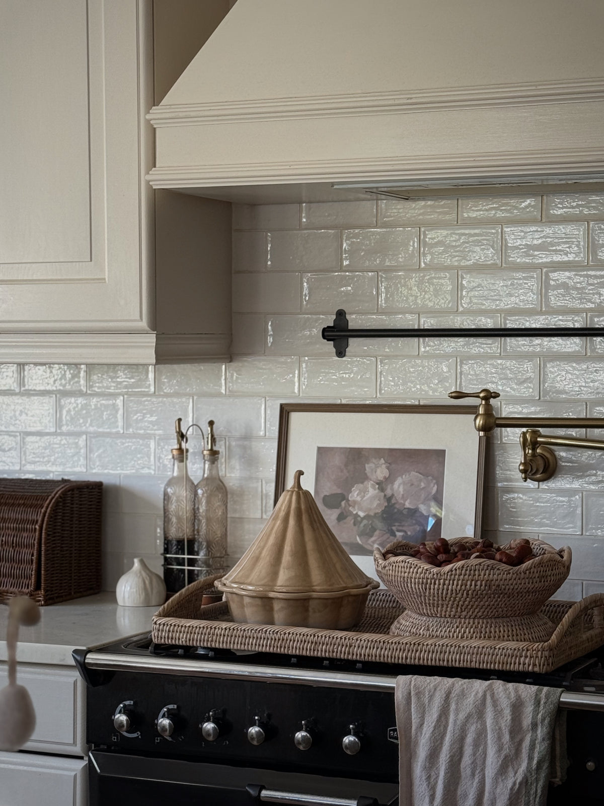 White wash rattan pedestal bowl styled in a country kitchen beside a range cooker