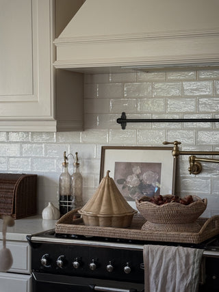 White wash rattan pedestal bowl styled in a country kitchen beside a range cooker