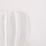 Textured off white glazed ceramic with ridged detail.