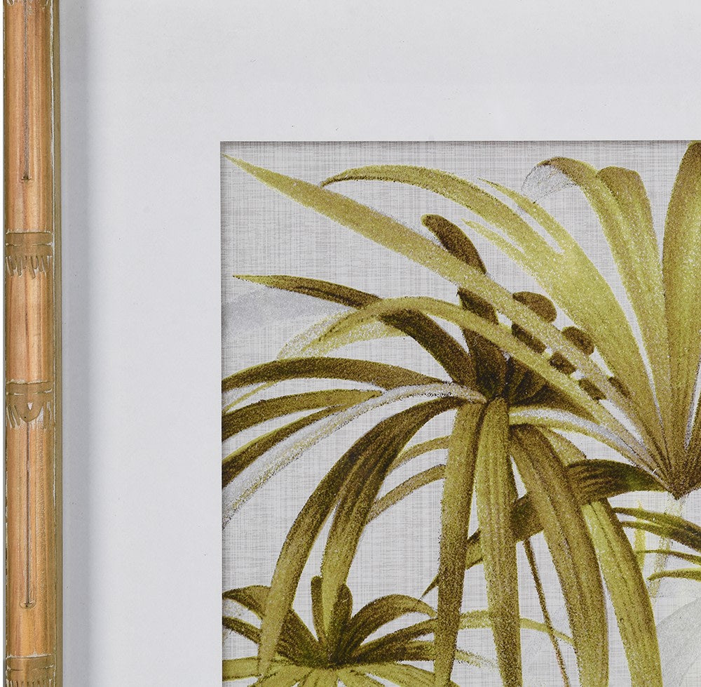 A set of two palm leaf framed wall art pieces complete in a bamboo effect wooden frame.