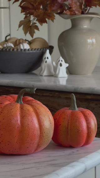 Autumn shelf styled with faux pumpkins, a stoneware vase and autumn leaves