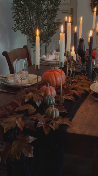 Candlelit harvest table styled with rustic orange faux pumpkins