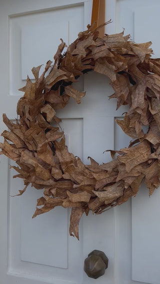 Autumn dried leaf wreath hanging on a door, shown up close