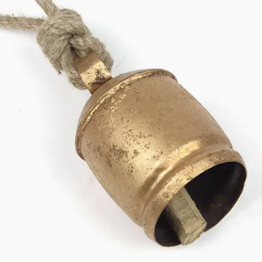 A bronze-colored metal cowbell with a rustic rope attached to it.