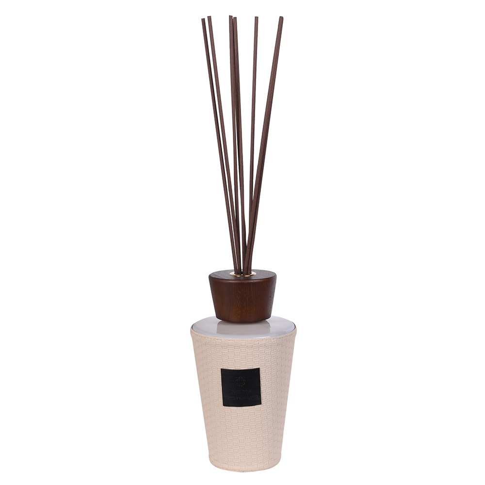 Saddle reed diffuser showing hand-cast basketweave cream vessel, sculpted dark walnut stopper and tall dark walnut reeds