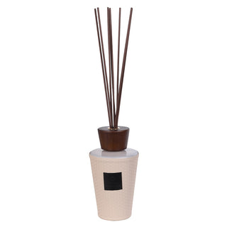 Saddle reed diffuser showing hand-cast basketweave cream vessel, sculpted dark walnut stopper and tall dark walnut reeds