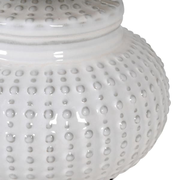 This white ceramic lamp base features a unique pattern reminiscent of an urchin, accompanied by a coordinating linen shade.