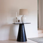 This luxuriously crafted lamp features a white ceramic base adorned with intricate beading, and accompanied by a natural linen shade.