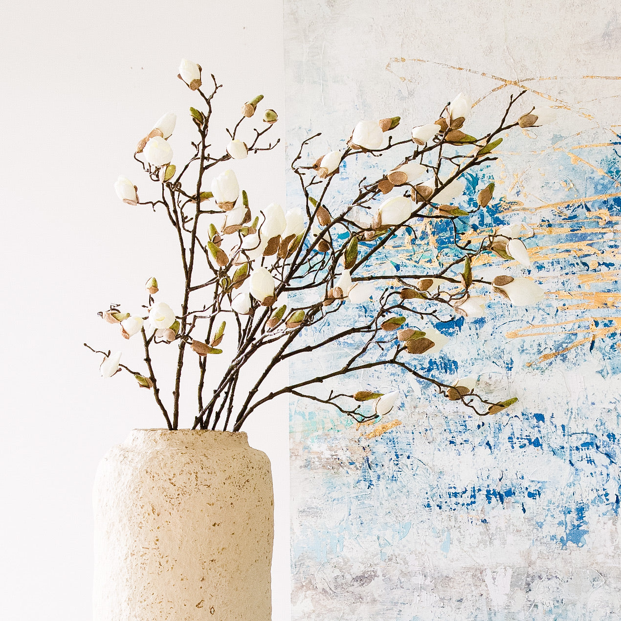 A beautiful stem of magnolia featuring bud detailing and blooming flowers.