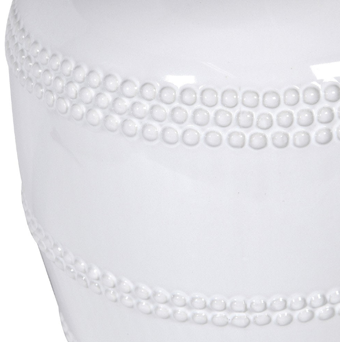 This luxuriously crafted lamp features a white ceramic base adorned with intricate beading, and accompanied by a natural linen shade.