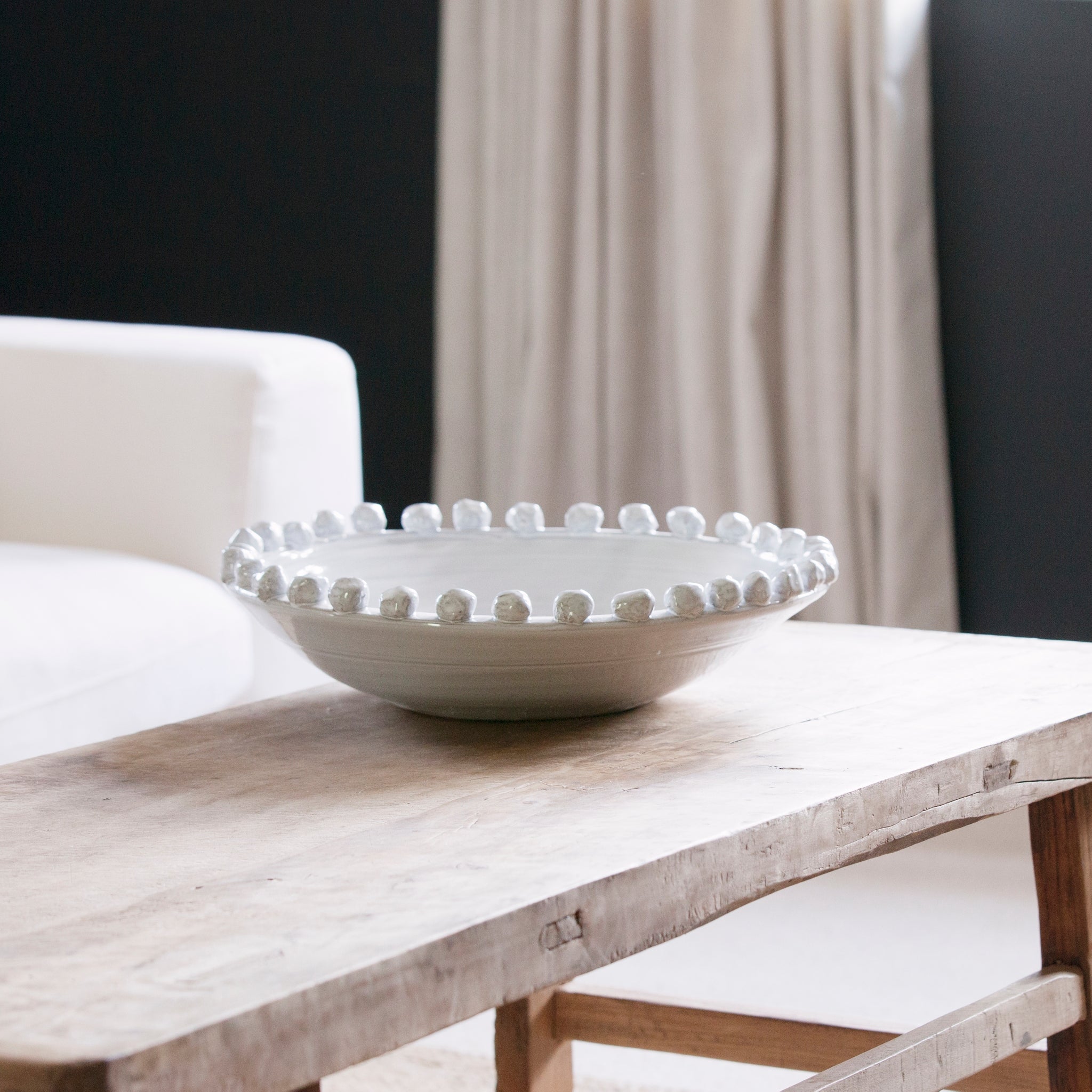 Ceramic white bobble bowl on a rustic coffee table