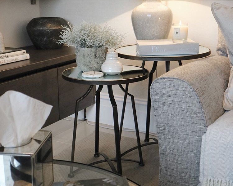 A beautiful set of two nesting tables finished crafted from metal and finished in warm bronze tones finished with a mirror top.